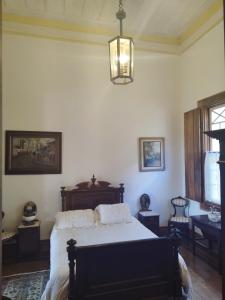 1 dormitorio con cama y lámpara de araña en Fazenda Cachoeira Grande, en Vassouras