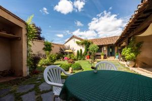 a green table and chairs in a yard at Descubre La Cepedana: Casa rural con encanto en Cogorderos, a solo 10 km de Astorga in Cogorderos