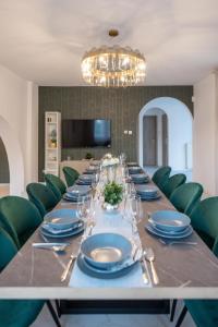 a dining room with a long table and green chairs at Stylish Vacation Home with AC - Stílusos légkondicionált nyaraló in Siófok