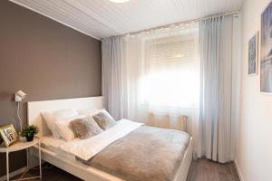 a small bedroom with a bed with a window at Stylish Vacation Home with AC - Stílusos légkondicionált nyaraló in Siófok +19 photos