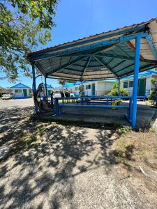 a blue picnic shelter with a bench in a park at Kenting Dajianshan Cabin in Kenting