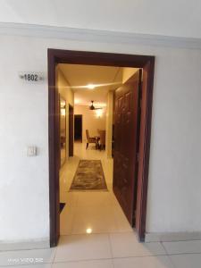イスラマバードにあるAQZ Apartmentsのリビングルーム付きの廊下への開放ドア