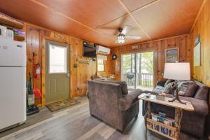 a living room with a couch and a refrigerator at Cozy Carp Lake Cottage with Dock, 4 Kayaks and Fire Pit in Carp Lake