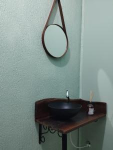 a bathroom with a sink and a mirror on a wall at Hotel Pousada e Parada Colonial in Capitão Leônidas Marques