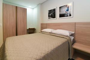 a bedroom with a bed and two pictures on the wall at Star Hotel Limoeiro in Limoeiro