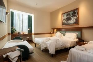 ペルージャにあるサンガロ パレスのベッド2台とデスクが備わるホテルルームです。