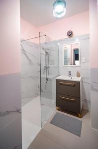 y baño blanco con lavabo y ducha. en Apartament KARMEL, en Przemyśl