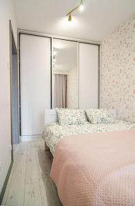 a bedroom with two beds and a large window at Apartament KARMEL in Przemyśl