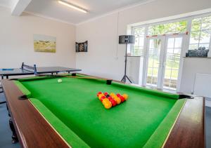Una habitación con una mesa de billar con pelotas. en Hafod Ganol Farm en Trehafod