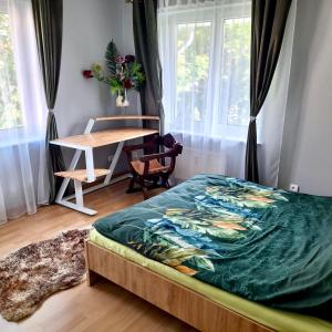a bedroom with a bed and a table and a desk at Apartament Deluxe in Jelenia Góra