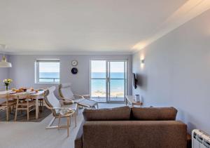 a living room with a couch and a table and chairs at Flat 9 Clifton Court in Croyde