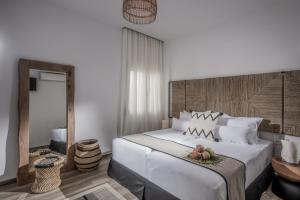 Schlafzimmer mit einem großen weißen Bett mit einem Kopfteil aus Holz in der Unterkunft Khroma Luxury Suite 1 Beach front apartment in Hersonissos