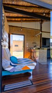 a living room with a table and a kitchen at Villa Taipas Chalé Iandê in Cavalcante