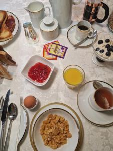 una mesa con platos de comida y tazas de café en Divine Cottage en Ballycastle