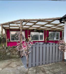 une maison rose avec une clôture devant elle dans l'établissement Mountain House Omeath near Carlingford, à Ó Méith
