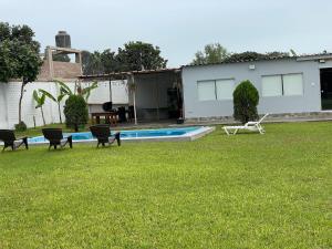un patio con sillas y una piscina en condominio haras de lurin, en Lurín