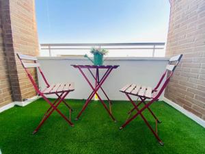 a table and two chairs on a patio with grass at NICE Apartment Close To The BEACH in Valencia