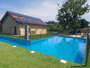 a swimming pool with a house with solar panels on it at El mirador del Valle in Obregón