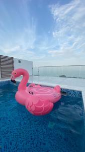 a pink inflatable pink swan in a swimming pool at Seascape Villa in Fujairah