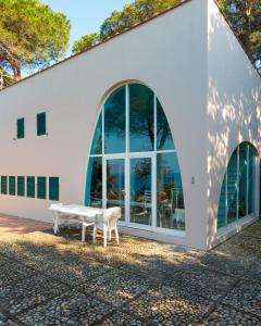 a white building with a bench in front of it at Villa I Coralli in Portoferraio