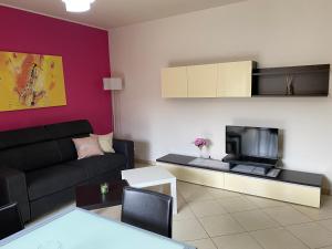 a living room with a couch and a tv at CASA VACANZA DAMAR in Mascali