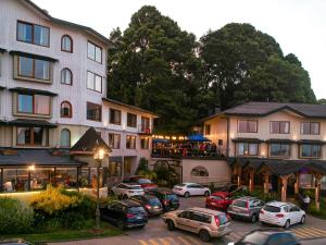 a group of buildings with cars parked in a parking lot at Hotel Bellavista in Puerto Varas