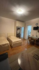 トビリシにあるTamara`s Apartament in Avlabariのベッド2台、テーブル、デスクが備わる客室です。