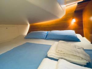 Boat and Breakfast في باليرمو: غرفة نوم بسرير وملاءات ووسائد زرقاء