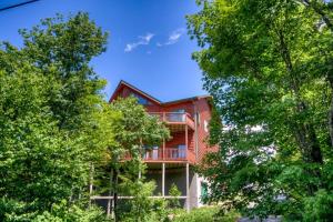 una grande casa in legno con alberi di fronte di Mountain Top Lodge a Beech Mountain