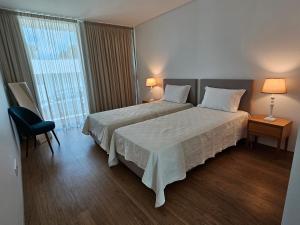 um quarto de hotel com uma cama e uma janela em Galé T3 em Caloura