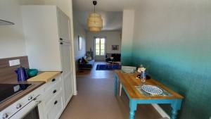a kitchen with a table in the middle of a room at La Tour Bleue in Chânes