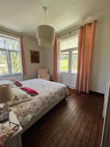 Schlafzimmer mit einem Bett, einem Stuhl und Fenstern in der Unterkunft Les 3 Soeurs in Han-sur-Lesse