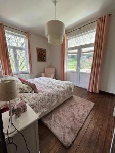 Schlafzimmer mit einem Bett, einem Tisch und Fenstern in der Unterkunft Les 3 Soeurs in Han-sur-Lesse