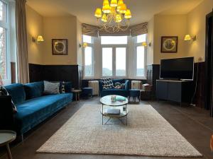 a living room with a blue couch and a tv at Les 3 Soeurs in Han-sur-Lesse