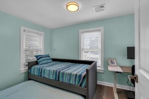 ein Schlafzimmer mit einem Bett und zwei Fenstern in der Unterkunft Unbeatable Location - 6 min walk to Asbury Park & Ocean Grove Main St in Ocean Grove