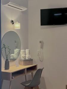 a room with a mirror and a desk with a chair at ATHANASIA APARTMENTS in Skiathos Town