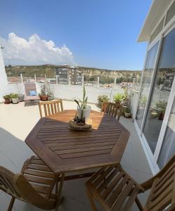 een houten tafel en stoelen op een balkon bij Sun & Sea rooftop in Costa da Caparica