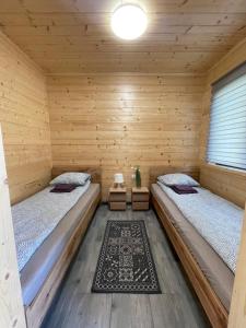 Brzozowy Zakątek Zator في زاتور: غرفة بسريرين في كابينة خشبية