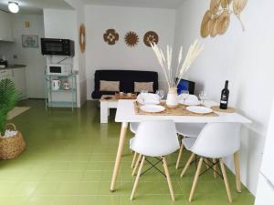 una mesa blanca con sillas blancas en la cocina en Charmant Appartement Casa Freesia Caleta avec piscine, en Caleta de Fuste