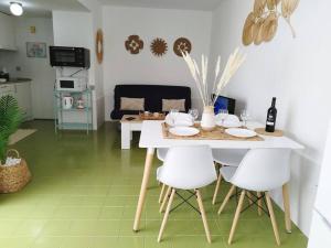 a white table with white chairs in a kitchen at Air-conditioned flat Casa Freesia Caleta de Fuste in Caleta De Fuste