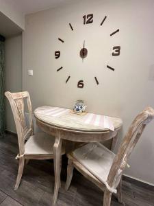 a table and two chairs with a clock on the wall at Velvethouse in Velventós