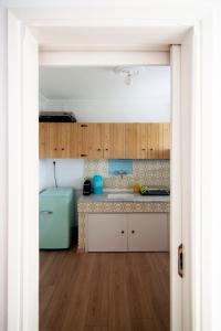 a kitchen with wooden cabinets and a blue refrigerator at Mini studio apt. in Epanomi