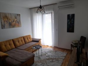 ein Wohnzimmer mit einem Sofa und einem Fenster in der Unterkunft Apartman Nomino in Zvornik