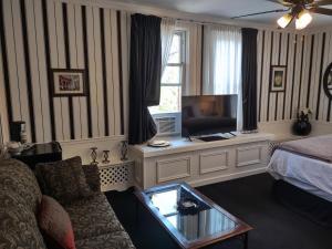 a living room with a couch and a tv in a room at The King George Inn in Cobourg