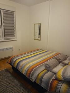 a bedroom with two beds and a window at Apartman Nomino in Zvornik