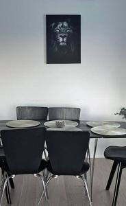 a table with four chairs and a lion picture on the wall at New Magnificent view apartment Near the centre in Tromsø