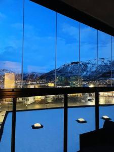 ventana grande con vistas a una montaña nevada en New Magnificent view apartment Near the centre en Tromsø