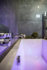 a bathroom with a purple tub and a sink at Kotlina 11 in Murzasichle