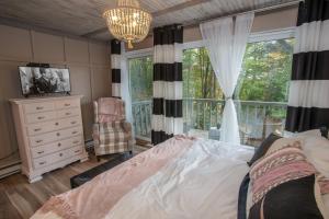 a bedroom with a bed and a dresser and a window at Skyleaf on Sugar in Sugar Mountain