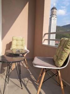 einen Balkon mit einem Tisch, Stühlen und einem Leuchtturm in der Unterkunft Apartman Nomino in Zvornik